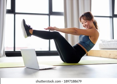 Asian Woman Excercising At Home, Watching Video Tutorial On Laptop, Workout On The Floor. Sport Online Concept