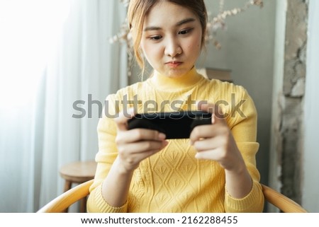 Asian woman excited while playing mobile games, reading good news while surfing the internet world.