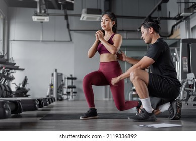 Asian Woman Exercises With Personal Trainer In Gym. Asian Healthy Woman Doing Legs Workout In Fitnees With Personal Coach.