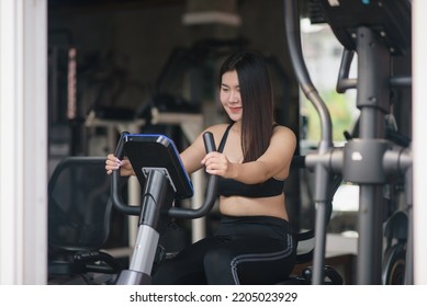 Asian Woman Exercising On A Bicycle In The Gym, Smiling To Lose Weight, Makes Her Healthy. Exercise Bike Woman Fitness Sport Concept.