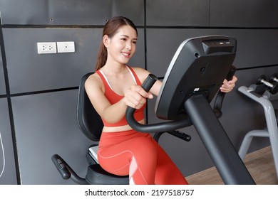 Asian Woman Exercising On Exercise Bike In Fitness Health Care Concept.