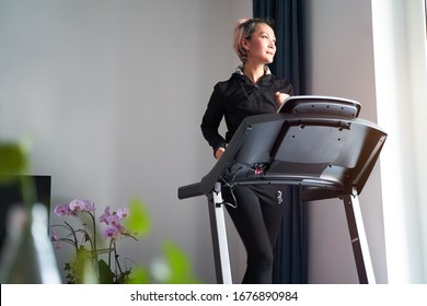 Asian Woman Exercising On Treadmill Home Gym