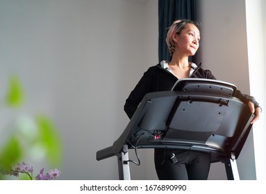 Asian Woman Exercising On Treadmill Home Gym