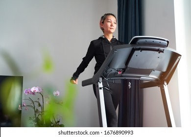 Asian Woman Exercising On Treadmill Home Gym