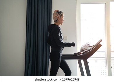 Asian Woman Exercising On Treadmill Home Gym