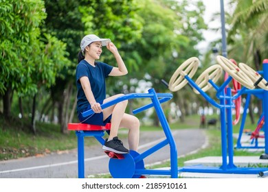 Asian Woman Exercising Riding On Spinning Bike At The Outdoor Park.Healthy Lifestyle And Sport Concepts.