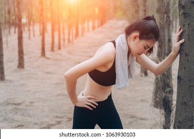 Asian Woman Exhausted Or Tired After Training Workout At Forest Nature In The Morning With Cardio Runner Marathon,run Out Of Energy Healthy Lifestyle.