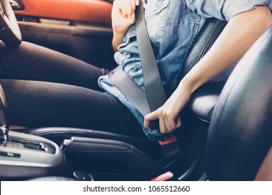 Asian woman fastening seat belt in the car, safety concept