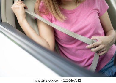 Asian Woman Fastening Seat Belt In The Car