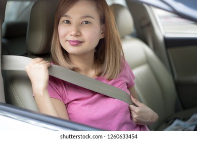 Asian Woman Fastening Seat Belt In The Car