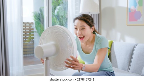 Asian Woman Feel Hot And Sweaty Use Hand Fanned To Cool Down In Summer Sit On Sofa At Home