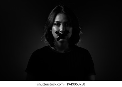 Asian Woman feel injustice, insecure and corruption in society So she closes Mouth with duck tape, Concept not to say a word. Dark tone environment copy space