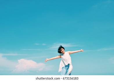 Asian Woman Feeling Excited Standing In Front Of Blue Sky Background,copy Space 