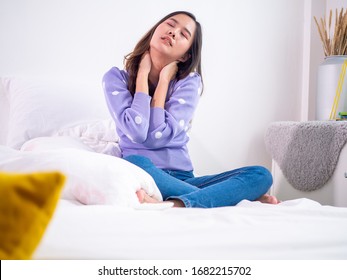 Asian Woman Feeling Neck Ache, Suffering From Painful Feeling In Neck In Morning After Sleeping On Uncomfortable Pillow At Home Or Hotel Room.