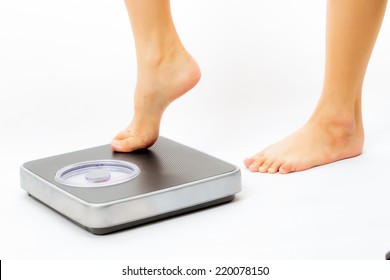 asian woman feet on scales in white background - Shutterstock ID 220078150