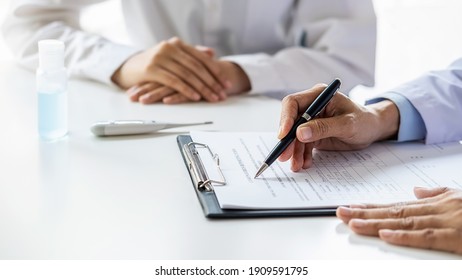 Asian woman filling a coronavirus self reporting form with a doctor recommended at hospital. Medical and Health concept.