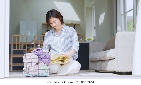 Asian woman folding a towel - Powered by Shutterstock