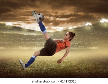 Asian Woman Football Player Kick Ball On The Stadium