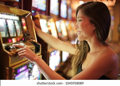 Asian woman gambling in casino playing on slot machines spending money. Gambler addict to spin machine. Asian girl player, nightlife lifestyle. Las Vegas, USA. - Shutterstock ID 1045958089