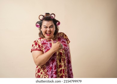 An Asian woman gesturing okay sign using her hand. Isolated on cream background. 