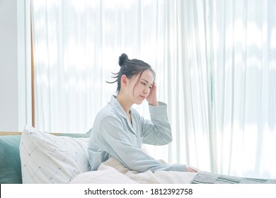 Asian Woman Getting Up With Headaches