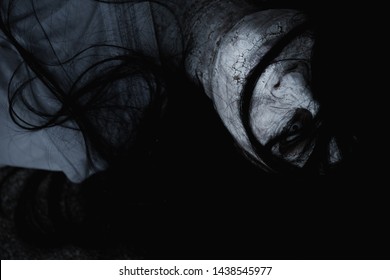 Asian woman ghost or zombie horror creepy scary close up she face and hair covering the face her eye looking to camera, Halloween day concept, in dark tone