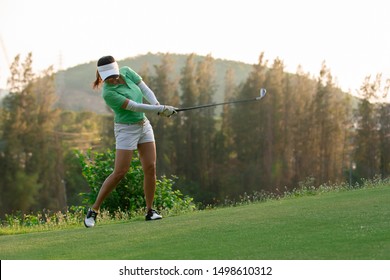 Asian Woman Golfer Playing Golf At Golf Course ,Golfer Hitting Golf Ball , Healthy Holiday Concept