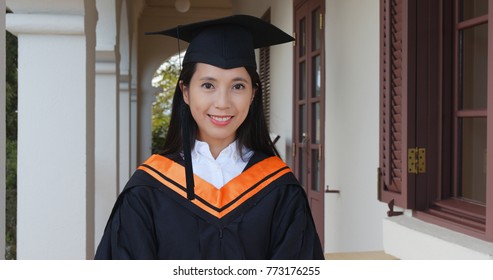 Asian woman with graduation gown in university campus  - Powered by Shutterstock