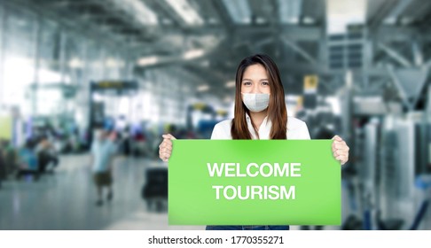 Asian Woman Guide Tour Hold Welcome Greeting Banner For Show To Tourism In Airport After Coronavirus Pandemic Open Lock Down.