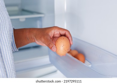 Asian woman hand picking egg, to organize fresh raw eggs on the shelf to keep cool in refrigerator. - Powered by Shutterstock