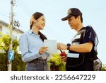 Asian woman handing over piece of paper asking for help from male security guard housing estate stand friendly and courteously inquiring about the journey and where stay those you know in the village.