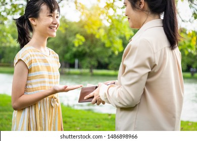 Asian Woman Hands Open Wallet,mother Or Guardian Giving Pocket Money To Daughter,smiling Beautiful Child Girl Demanding Money, Allowance,parent Pulls Out Money From Wallet To Give Her In Outdoor Park