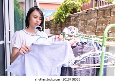 ํYoung Asian woman to hang dry the clothes.