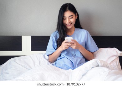 Asian Woman Happy Patient Resting In Bed At Hospital Private Room With Illness Disease Unhealthy Body, Panic Patient In Medical Health Care Insurance, Happy Cheerful Using Mobile Smartphone Internet