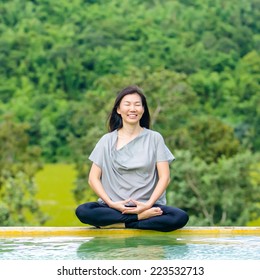 Asian Woman Is Happy And Smiling With Meditating By The Pool Side.