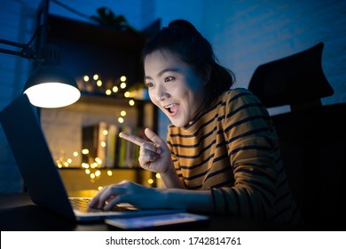 Asian Woman Happy Smiling Working On A Laptop At The Night At Home. WFH. Work From Home Avoid COVID 19 Concept.