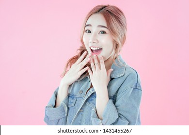 Asian woman happy with special deals & discounts of promotions, blue jean clothing, pink background