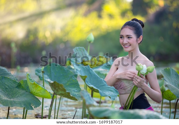 庭にハスの花を収穫するアジア人の女性 の写真素材 今すぐ編集