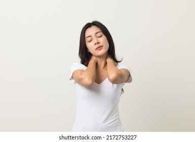 Asian woman has problem with structural posture She had neck and shoulder pain. She massaged her neck and shoulders for relief. reduce muscle tension. Standing on isolated white background - Shutterstock ID 2172753227