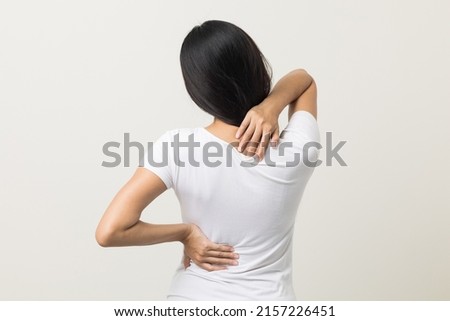 Asian woman has problem with structural posture She had neck and back pain. She massaged her neck and shoulders for relief. reduce muscle tension. Standing on isolated white background