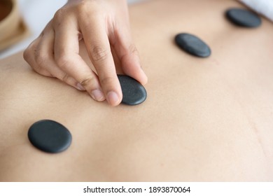 Asian Woman Having a Hot Stone Massage Treatment  in a Spa