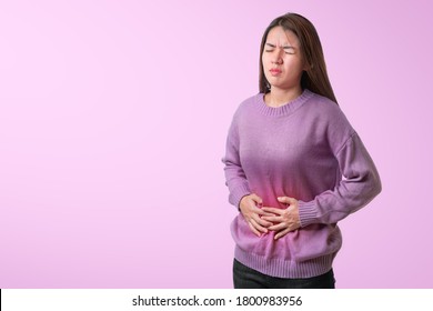 Asian Woman Having Painful Stomach Ache And She Used The Hand To Hold The Belly Isolate On Pink Background,Period Cramps, With Clipping Path.