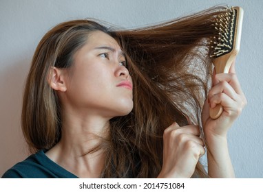 Asian Woman Having Problem Of Her Thick And Messy Hair While Using Hair Brush. Thick Hair Weights More Than Thin Hair And Prone To Damage And Frizzy.