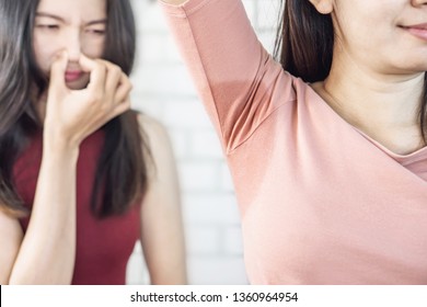 Asian Woman Having Problem Sweat Under Armpit  With Friend Smelling Stink In Background 