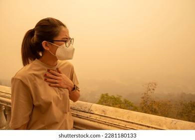 Asian woman having respiratory allergy caused of by Bad air pollution (PM2.5). PM2.5 levels meaning the air quality posed a health hazard.