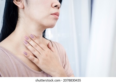 Asian woman having sore throat, hand touching neck feeling pain from inflammation  - Shutterstock ID 2078830435