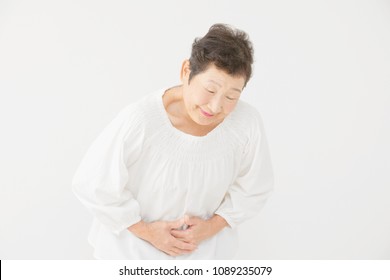 Asian woman having a stomachache - Powered by Shutterstock