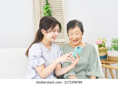 Asian woman and her grandmother talking with the smartphone at home - Shutterstock ID 2171598789
