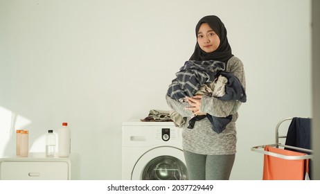 Asian Woman In Hijab Brings Her Laundry At Home