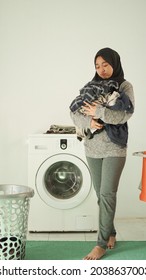 Asian Woman In Hijab Brings Her Laundry At Home